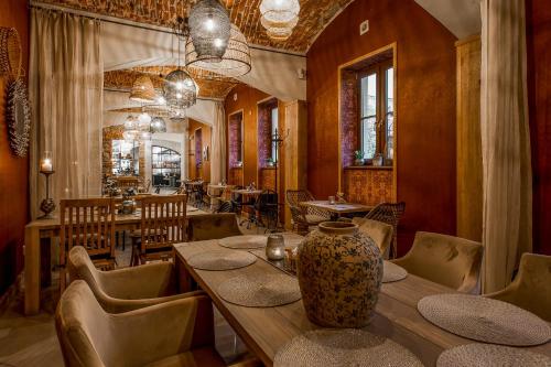 POETIKA apartments في بريشوف: مطعم به مزهرية كبيرة على طاولة خشبية