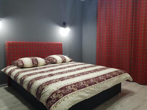 una camera da letto con letto con testiera rossa e cuscini di Апартаменты Yes Silver a Užhorod