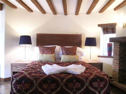 a bedroom with a large bed with two lamps at Ye Olde Red Lion in Newbury