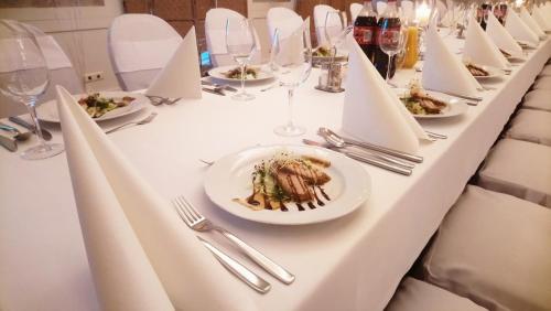 Hotel Milord في بوتوسك: طاولة طويلة مع أطباق من الطعام وكؤوس النبيذ