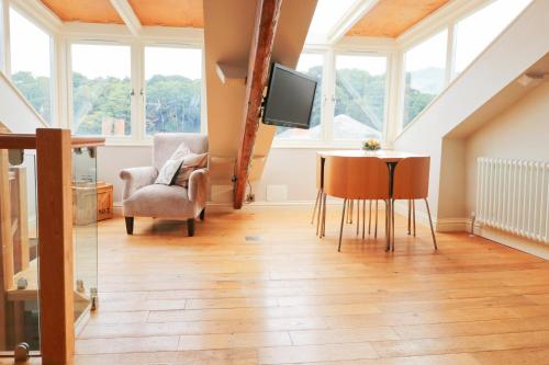 a living room with a table and chairs and a tv at TOWN CENTRE contemporary cottage in Padstow