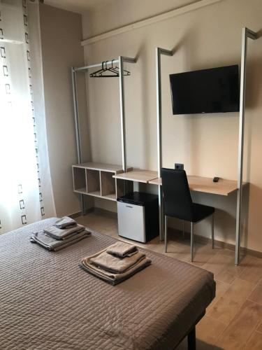 a bedroom with a bed with a desk and a chair at Riva Reno 4 Rooms in Bologna