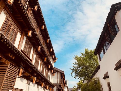 an old building with windows and a blue sky at Youxiake Canal Hotel Hangzhou in Hangzhou