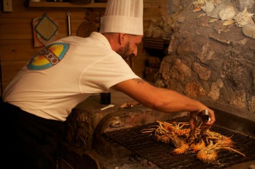 a man is cooking food on a grill at Da Fabio in Negril