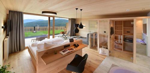 a living room with a large window and a couch at Tratterhof Mountain Sky Hotel in Maranza