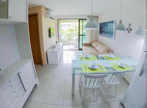 a kitchen and living room with a table and chairs at Flats no Carneiros Beach Resort in Tamandaré
