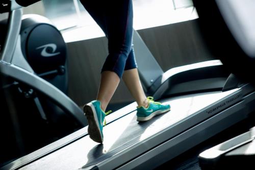 a person walking on a treadmill in a gym at Novotel Chennai OMR in Chennai