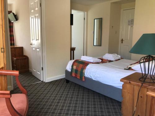 a bedroom with a bed and a table and a lamp at The Sherborne Lodge in Ilfracombe