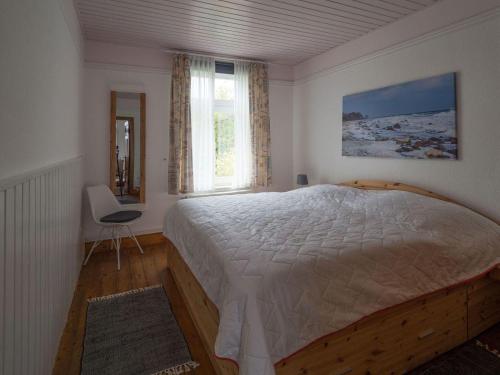 een slaapkamer met een groot bed en een raam bij Terrassenwohnung-Loenneberger-im-Ferienhof-Nielson in Bisdorf
