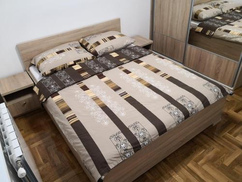 a bed in a room with a bed frame at Apartman Gaga in Lukavica