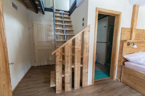 a staircase in a room with a bedroom and a bed at Stará škola in Dolní Malá Úpa