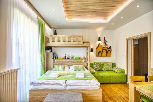 a bedroom with a bunk bed and a green couch at ORBIT TATRY Apartments, Starý Smokovec, Vysoké Tatry in Smokovce