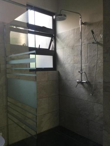 een badkamer met een douche en een glazen deur bij Atrium mit privatem Pool in Grand Baie