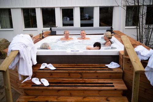 un grupo de personas en una bañera de hidromasaje en una terraza en Ronneby Brunn en Ronneby
