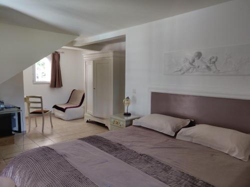 een slaapkamer met een groot bed en een stoel bij Domaine De Foresta in Bonifacio