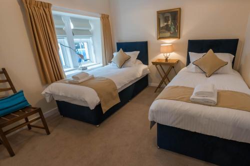 a bedroom with two beds and a window at The Clachan Inn in Drymen
