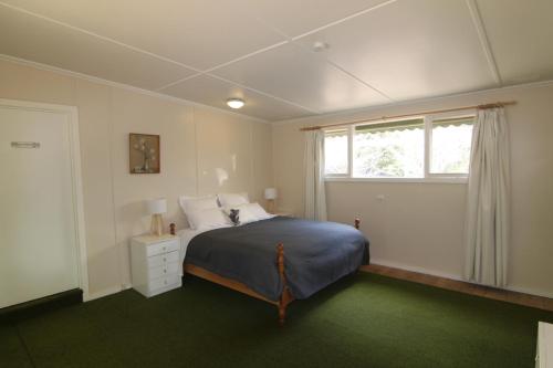 a bedroom with a bed and a window at Sunny Corner Lake Eildon in Eildon