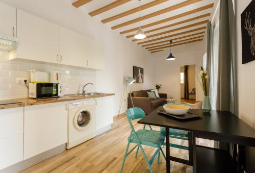 eine Küche und ein Wohnzimmer mit einem Tisch und einem Esszimmer in der Unterkunft Balcones de CANDELARIA by Cadiz4Rentals in Cádiz