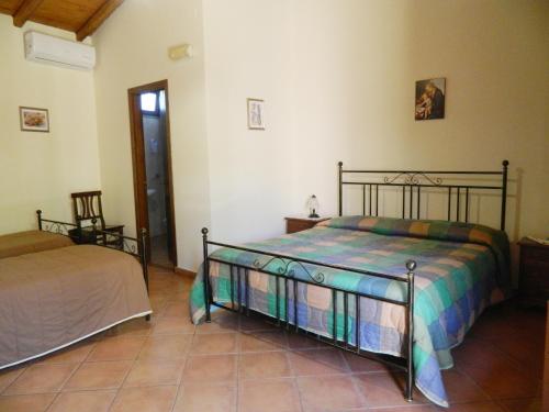 a bedroom with two beds in a room at Agriturismo La Grevillea in Riposto