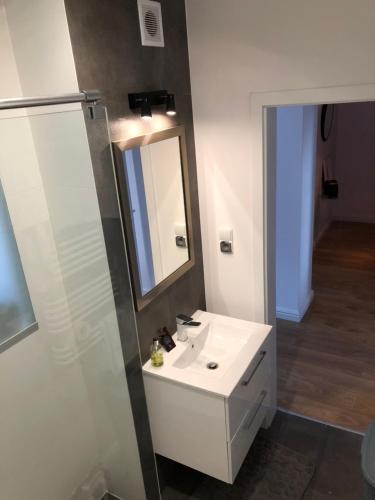 W łazience znajduje się biała umywalka i lustro. w obiekcie Apartament 'Laura' Tykocin w Tykocinie