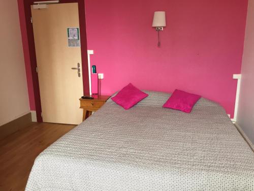 una camera rosa con un letto con due cuscini rosa di Le Vendangerot a Rully