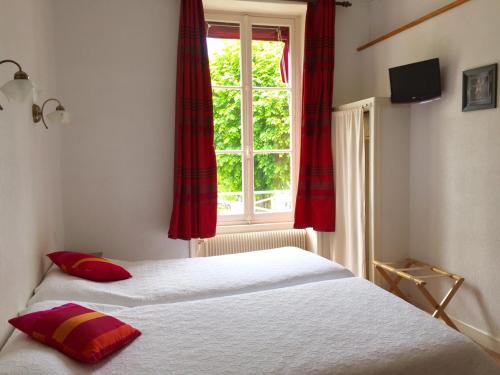 sypialnia z 2 łóżkami i oknem z czerwonymi zasłonami w obiekcie Le Vendangerot w mieście Rully
