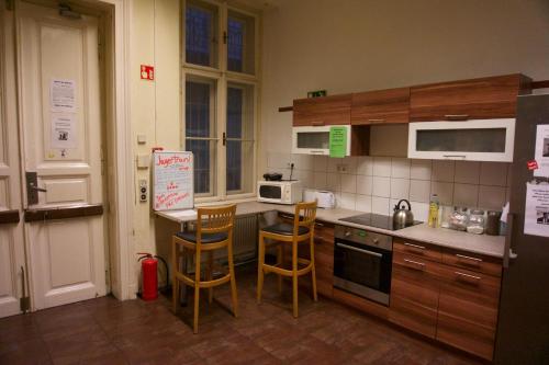 a kitchen with wooden cabinets and a counter top at Vitae Hostel in Budapest