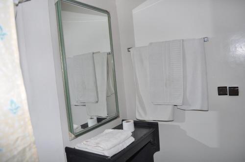 a bathroom with a mirror and a sink with towels at HOTEL SALIM in Casablanca