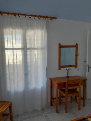 a room with a table and a mirror and a window at Katerina Kafieri Apartments in Firostefani