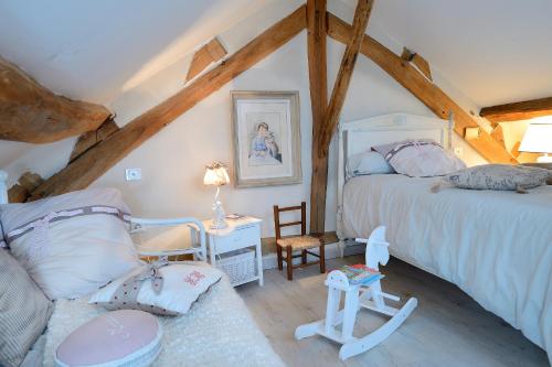een slaapkamer op zolder met 2 bedden en een bank bij Maison d'Hotes à l'Ombre Bleue in Mittainville