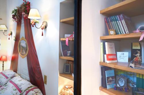 ミタンヴィルにあるMaison d'Hotes à l'Ombre Bleueの本棚の横に鏡付きのベッドルーム