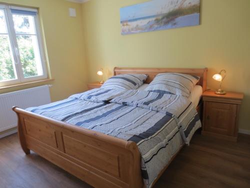 a bedroom with a wooden bed with pillows on it at Sigi sin Hus 26a in Prerow