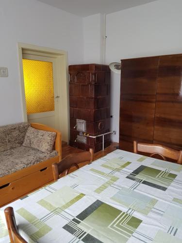 een kamer met een tafel, een bank en een bed bij Balázs Holiday Apartment in Băile Tuşnad