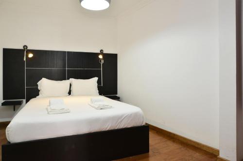 - une chambre avec un lit doté d'une tête de lit noire dans l'établissement Casa Ginja - Checkinhome, à Lisbonne