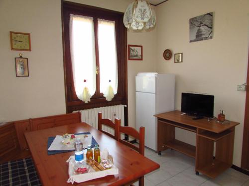 eine Küche mit einem Tisch und einem Kühlschrank sowie einem Tisch und Stühlen in der Unterkunft Casa Giuliano in Pincara