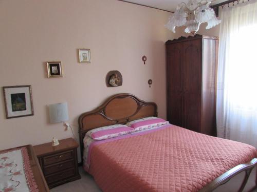 1 dormitorio con 1 cama con edredón rosa en Casa Giuliano en Pincara