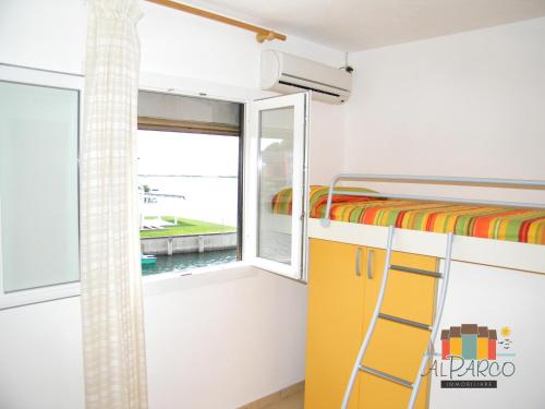 a bunk bed in a room with a window at Fiordo Mare Vostrum in Isola Albarella