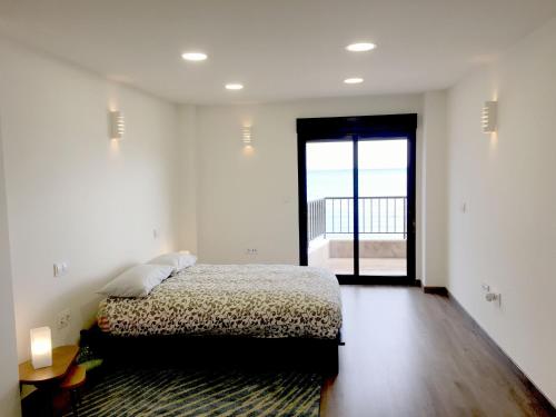 een slaapkamer met een bed en een groot raam bij CostaAzul loft, Seaviews frente al mar, Playa los locos in Torrevieja