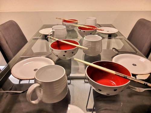 a glass table with bowls and chopsticks on it at Strait Garden Suites X Ace Pro @ George Town in Jelutong