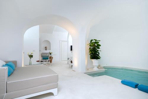 a white room with a swimming pool next to a bed at Bellevue Syrene in Sorrento