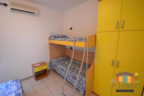 a bedroom with bunk beds and a yellow cabinet at Fiordo Specchio Nautico in Isola Albarella