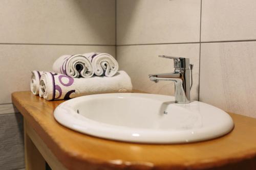 a white sink in a bathroom with towels on a counter at Holiday house Jereka -Bohinj in Bohinj