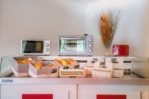 a counter with baskets of bread and a microwave at Premiere Classe Rungis - Orly in Rungis