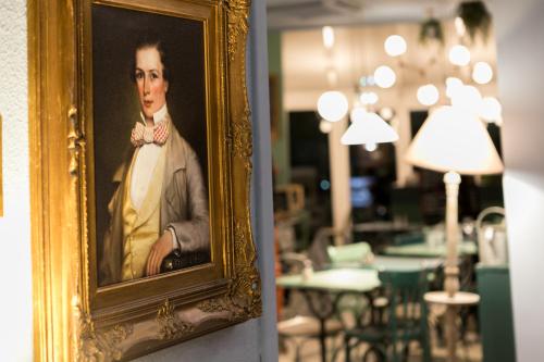 a painting of a man in a suit and bow tie at ibis Nantes Saint Herblain in Saint-Herblain