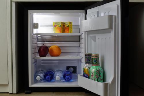 un frigorifero a pianta aperta con bevande, succo d'arancia e succo di frutta di Napoli City Rooms a Napoli