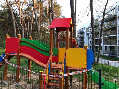 a playground with a slide in a park at Family & Business Sauna Apartments No1 Leśny nad Zalewem Cedzyna Unikat - 3 Bedroom with Private Sauna, Bath with Hydromassage, Terrace, Garage, Catering Options in Kielce