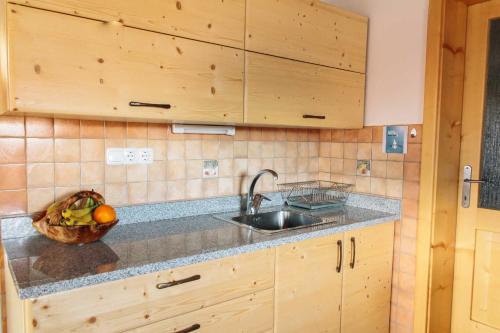 een keuken met een wastafel en een fruitschaal bij Holiday house Pokrovec - Bohinj in Bohinj