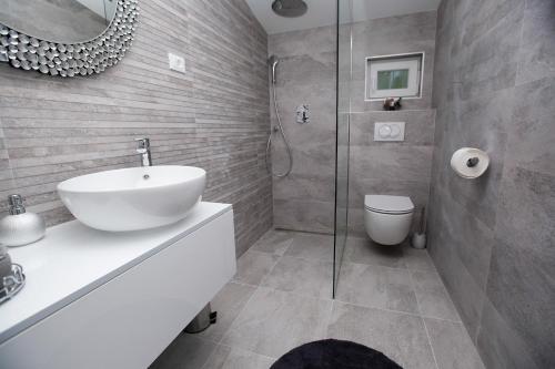 a bathroom with a sink and a glass shower at Luxury Apartments Mia in Podstrana