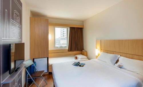 聖若澤的住宿－ibis Sao Jose，酒店客房设有一张大床和一台电视。