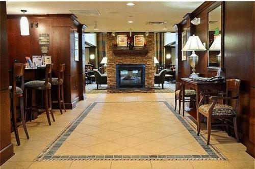 a lobby with a fireplace and a table and chairs at Staybridge Suites Williamsville Buffalo by IHG in Williamsville